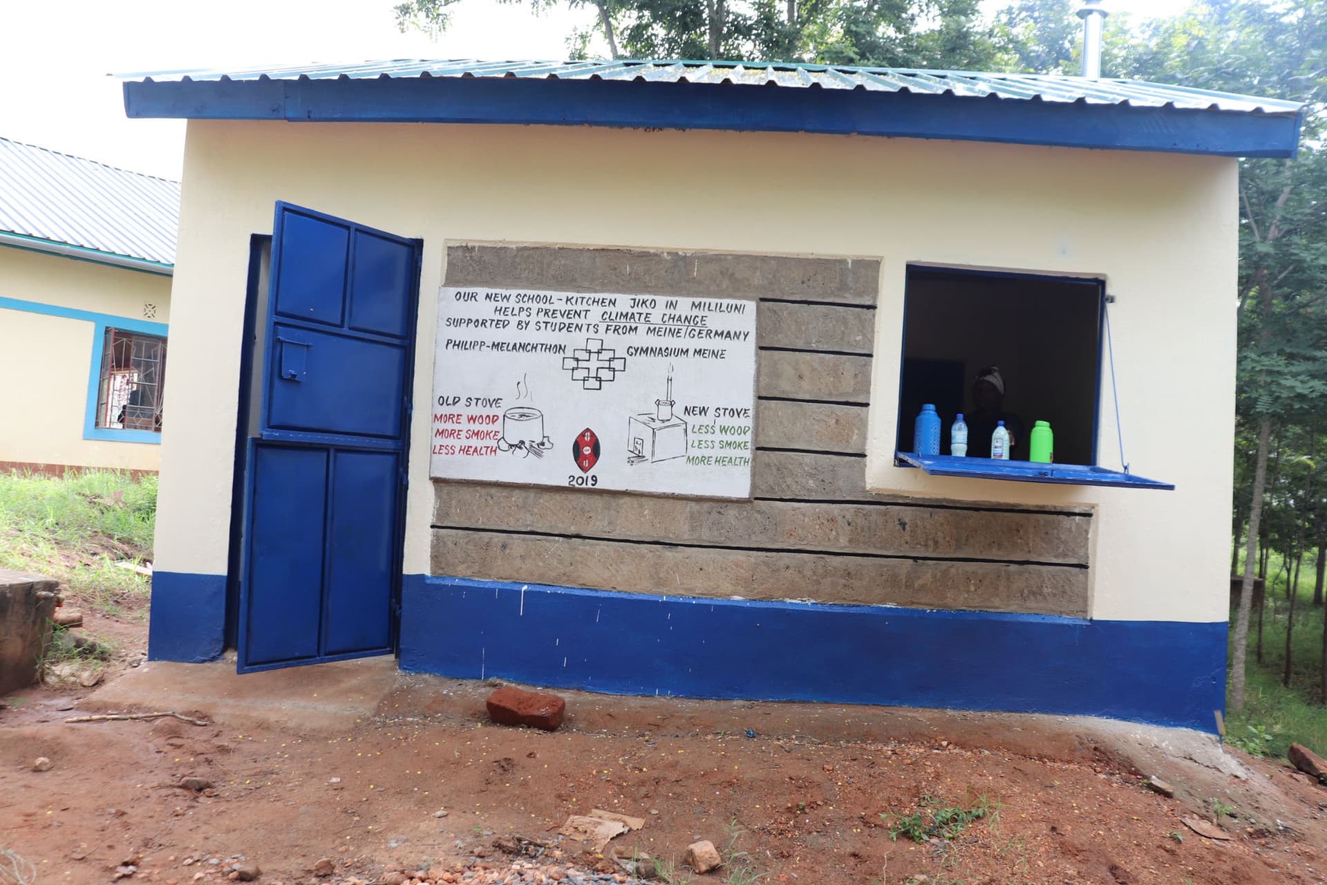 New school kitchen with a Jiko stove and a hand-painted information board in Mililuni